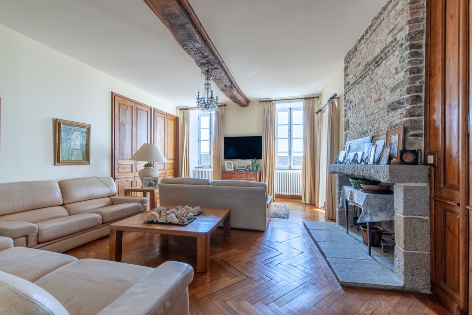 Petit salon avec cheminée en pierre et poutre maîtresse